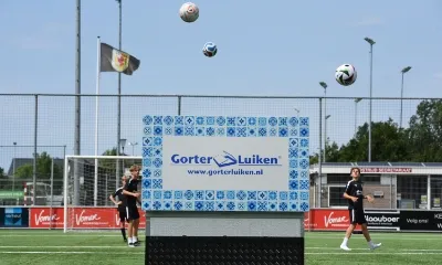 Gorter dakluik op een voetbalveld met allemaal voetballen in de lucht