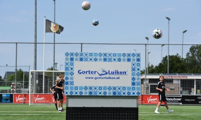 Gorter dakluik op een voetbalveld met allemaal voetballen in de lucht